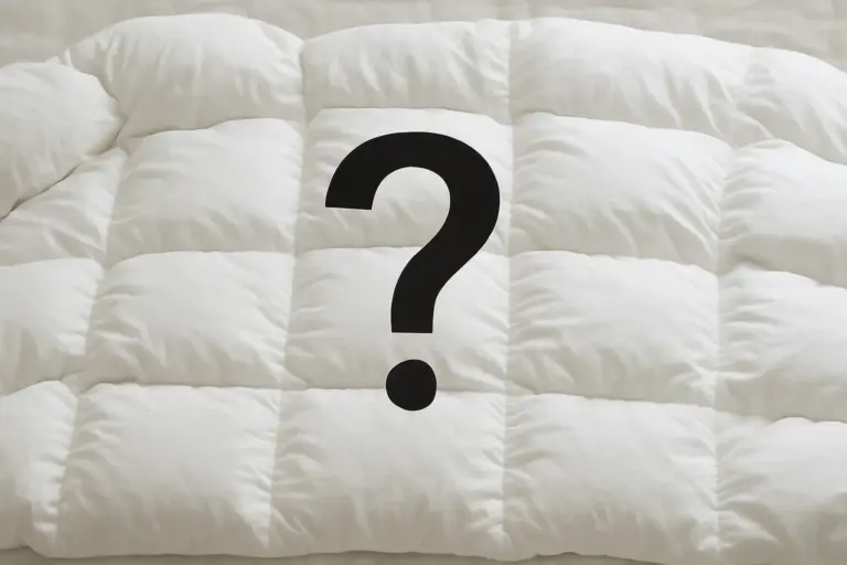 A fluffy white down comforter with a large question mark, symbolizing questions about down bedding and allergies.
